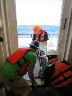Researchers carefully move the Carbon Flux Explorer robotic float out to the deck for deployment. (Credit: William Kumler)