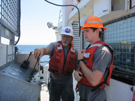 Doug Beck, the bosun on Oceanus, teaches UC Berkeley student William Kumler how to work the controls of the stern winch. (Photo: Sarah Yang)